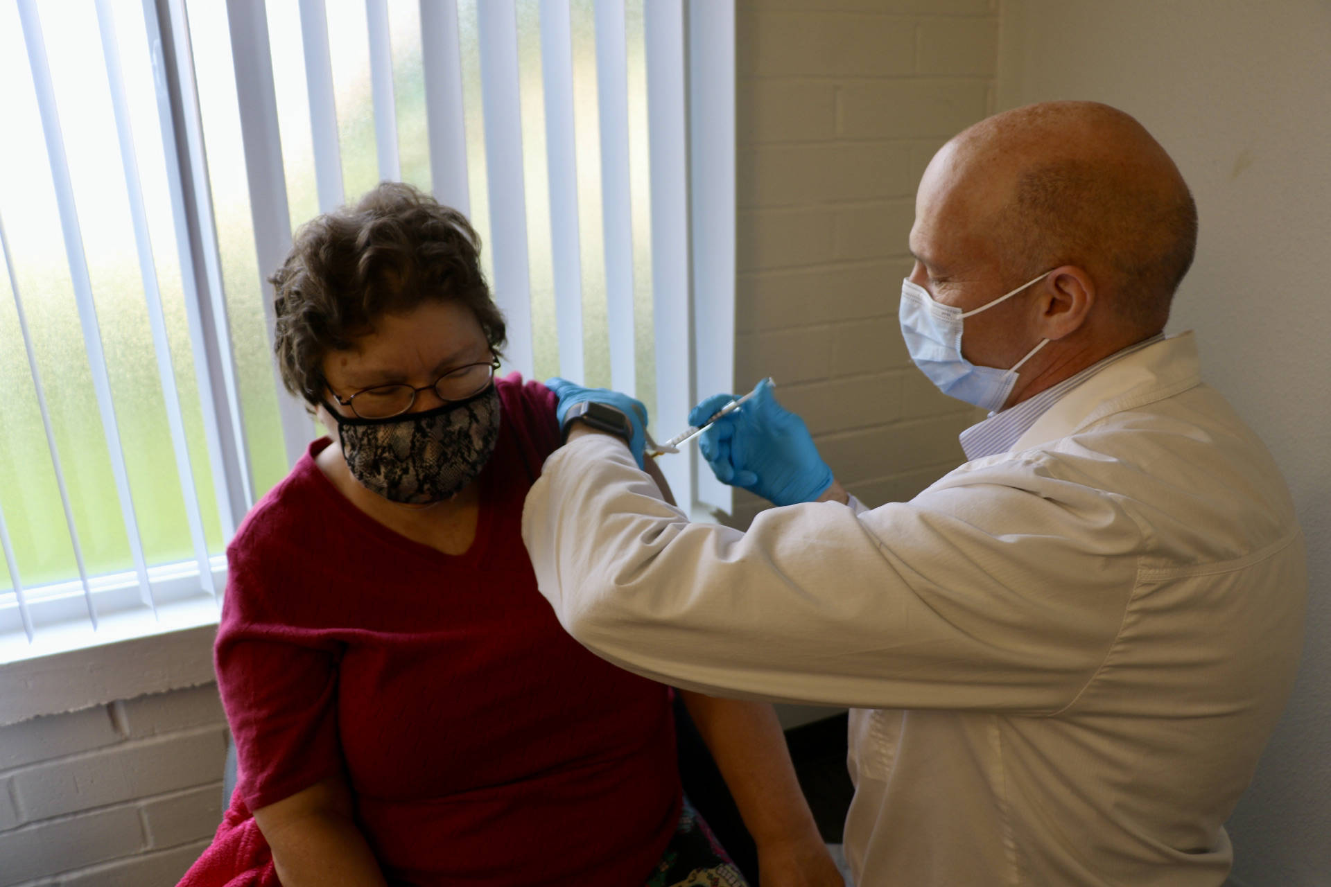 Safeway Pharmacist Tore Hagerup administers the first round of COVID-19 vaccination to Wendy Webster.