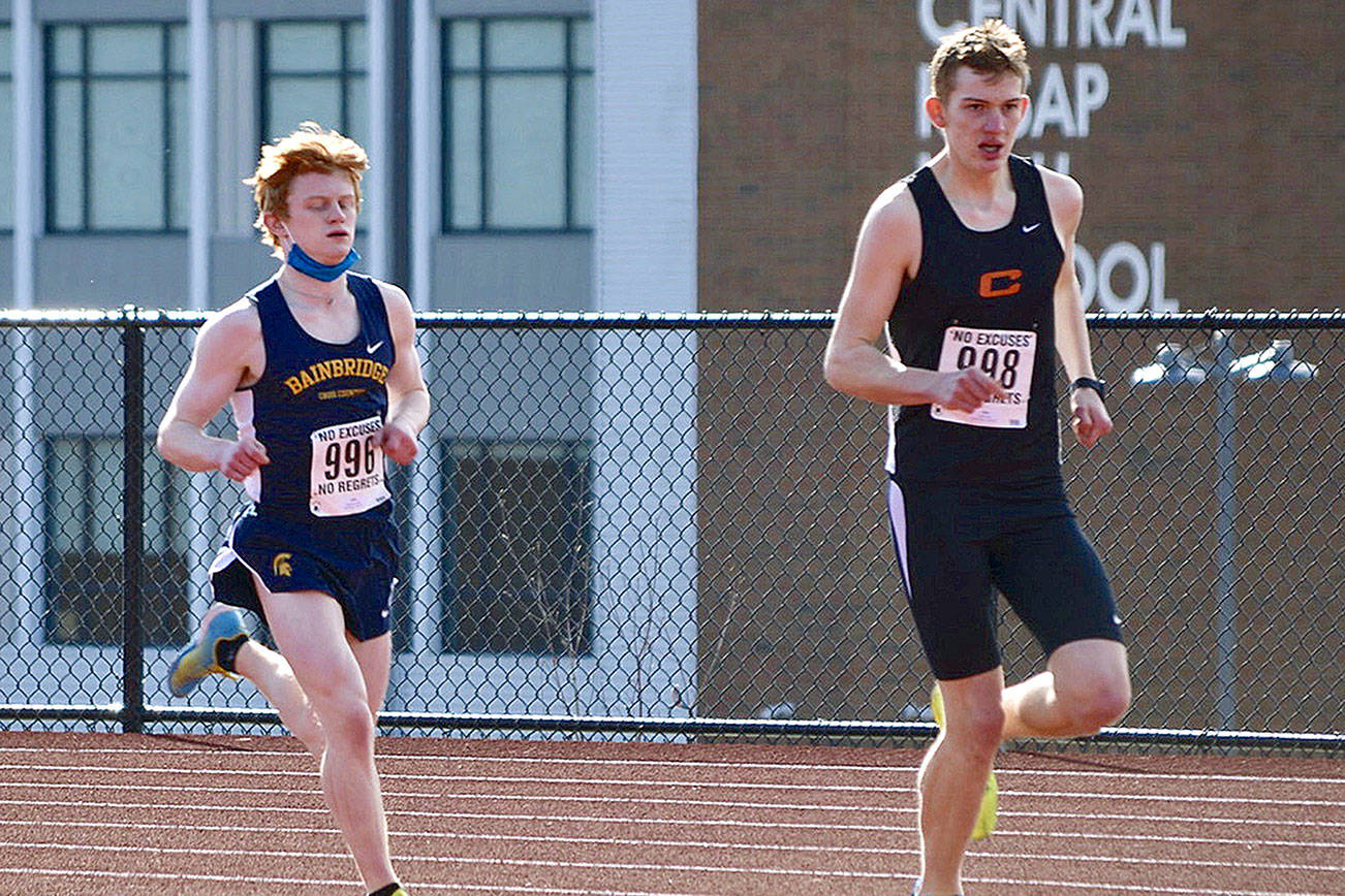 Bainbridge’s Alex Miller chases down Central Kitsap’s Daniel Lizon in the second Olympic League meet of the season. Miller won the race with a time of 17:20.20. (Photo courtesy of Rick Peters)