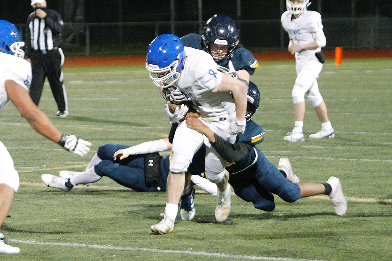 The Bainbridge defense tries to wrap up Olympic running back Trent Feistner. (Mark Krulish/Kitsap News Group)