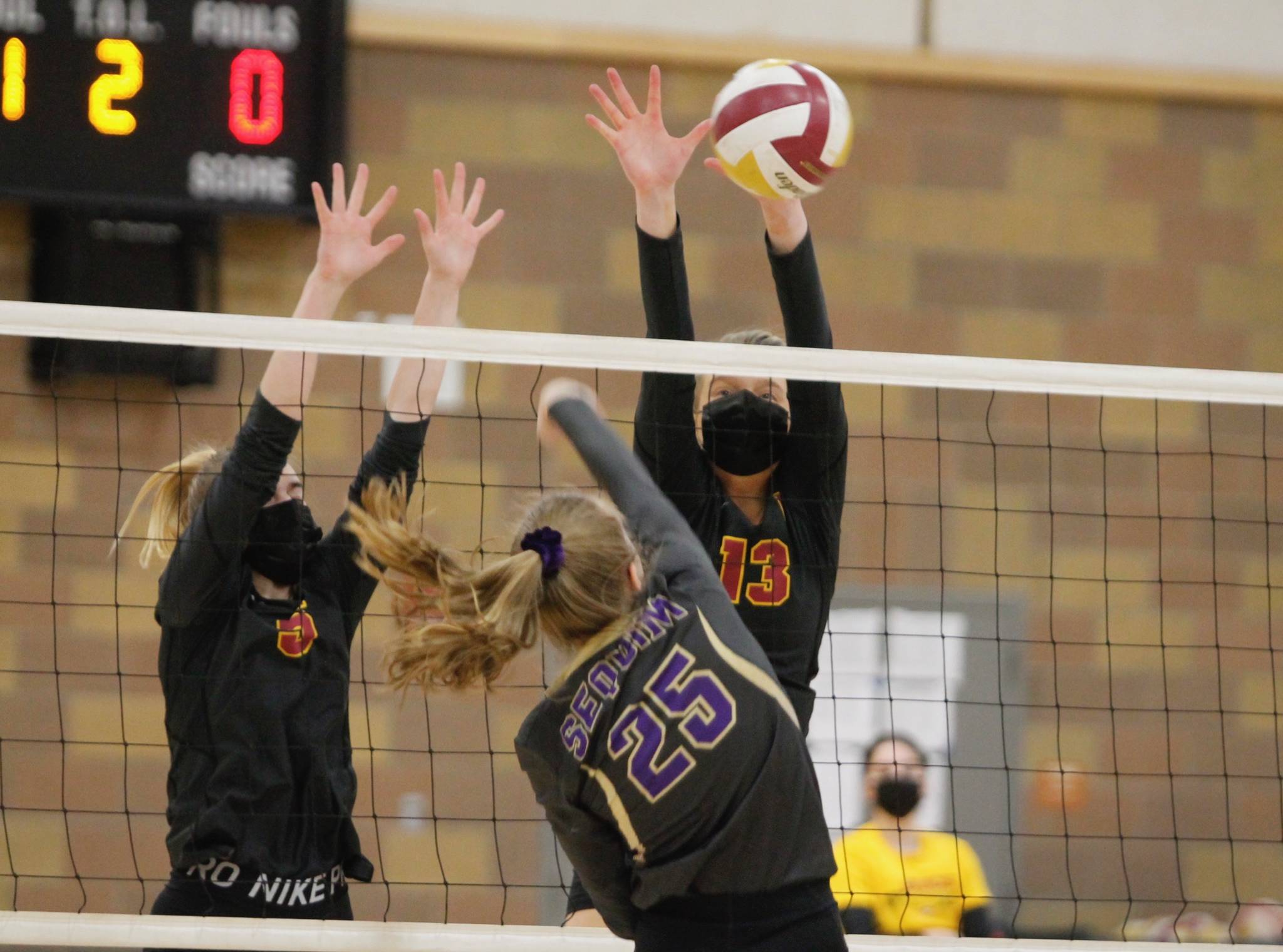 Morgan Halady (13) and Suzanne Skinner (5) block a kill attempt by Sequim’s Jolene Vaara during Kingston’s victory over the Wolves. (Mark Krulish/Kitsap News Group)
