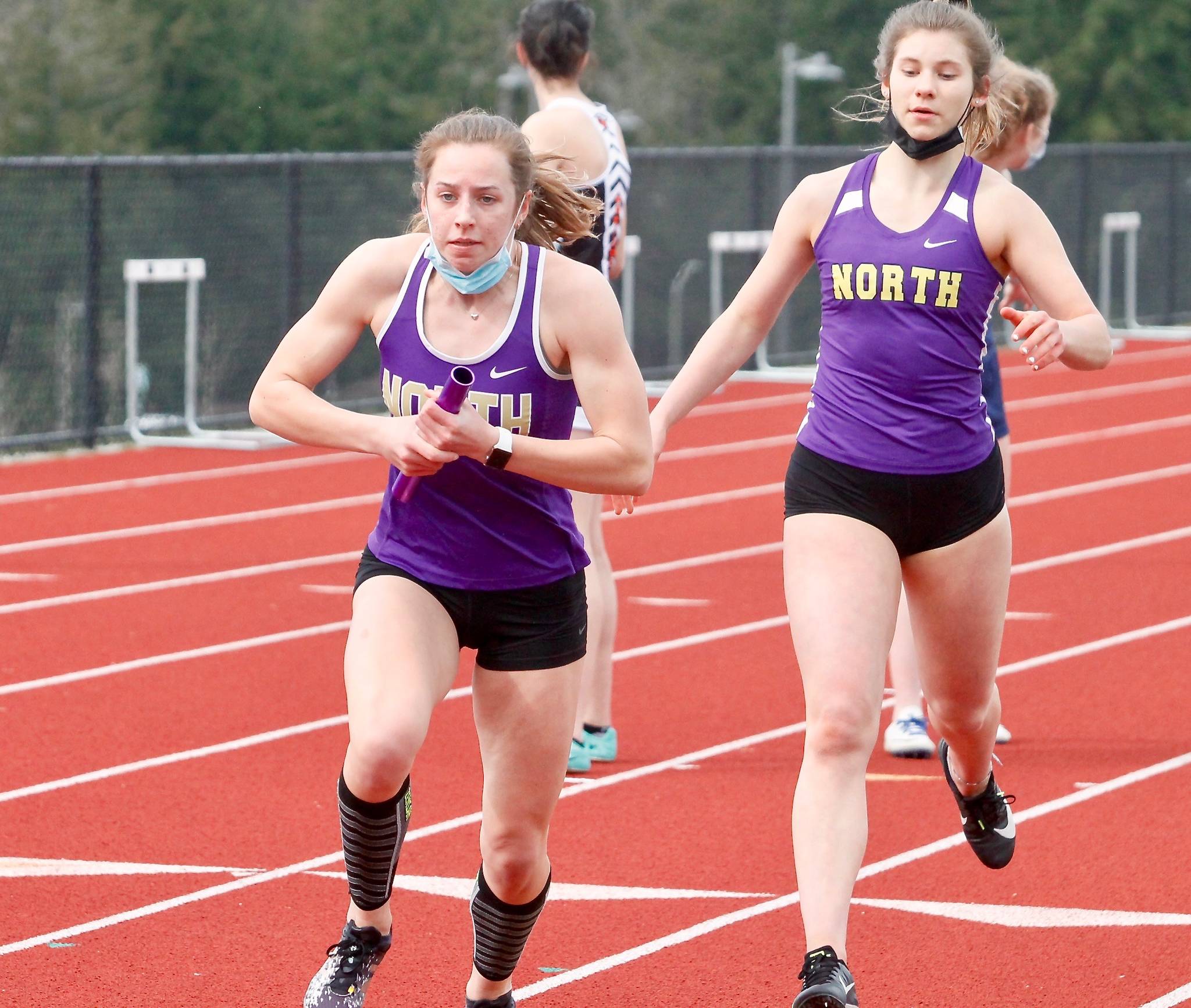 North Kitsap’s Alyssa Cullen (front) takes the baton from Genesi Funston in the 4x200 relay. (Mark Krulish/Kitsap News Group)