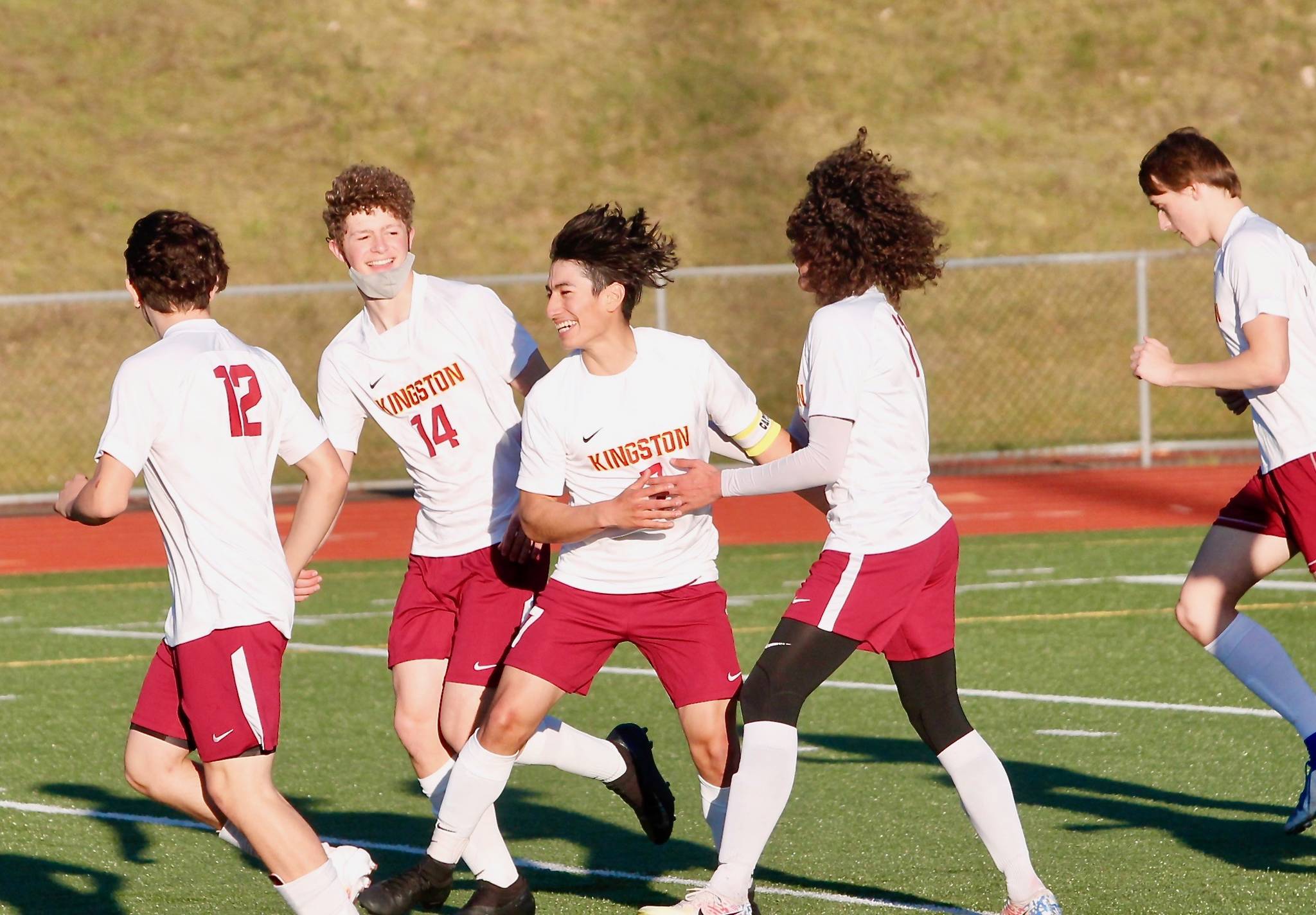 Kingston senior Kevin Aragon is surrounded by teammates after scoring his team’s opening goal against Olympic on Thursday. (Mark Krulish/Kitsap News Group)