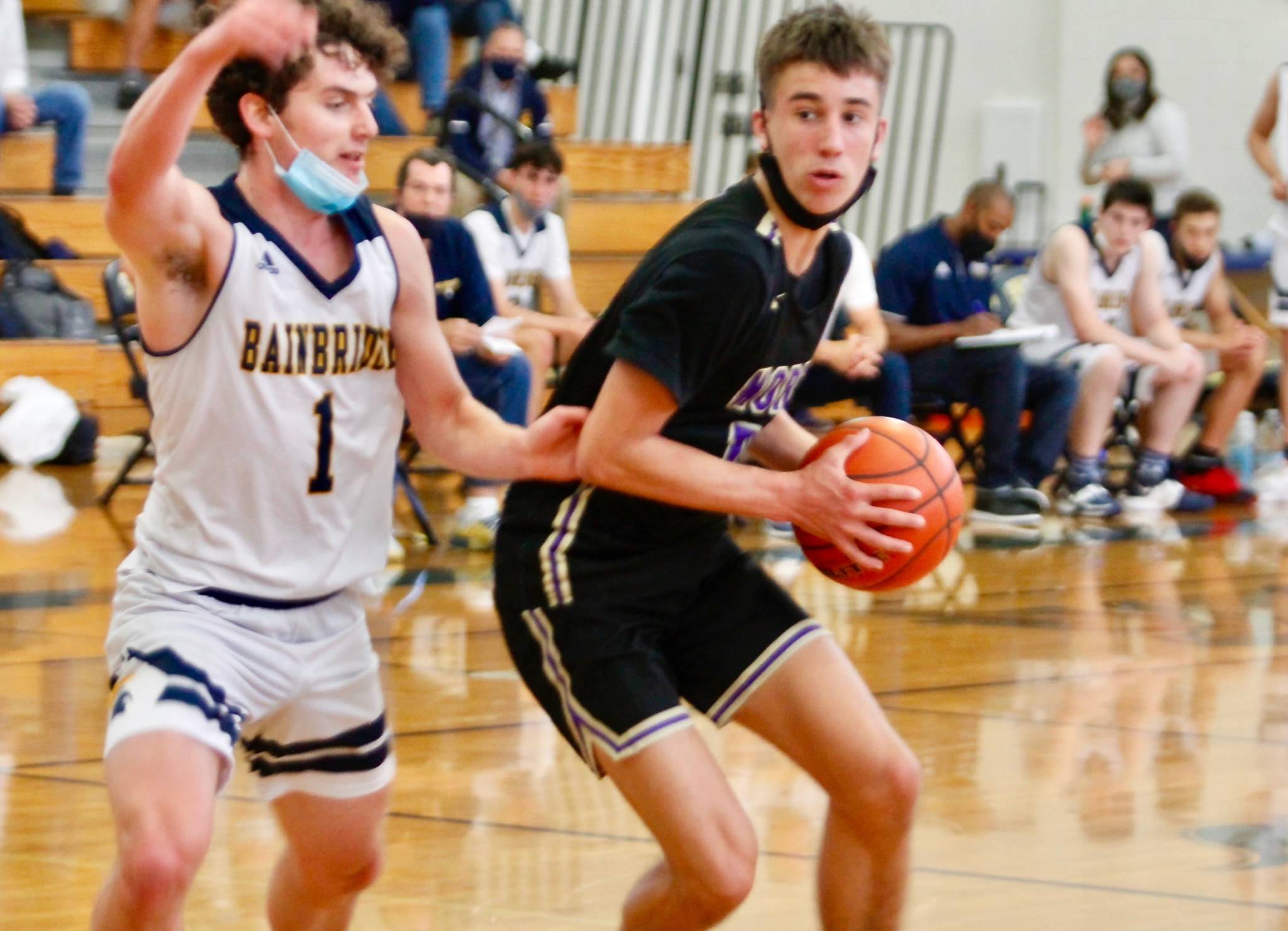 North Kitsap’s Cade Orness looks to dribble past Bainbridge guard Jacob Kirsch. Orness tied Monday’s semifinal match with a 3-pointer at the buzzer in regulation. The Vikings won in overtime. (Mark Krulish/Kitsap News Group)