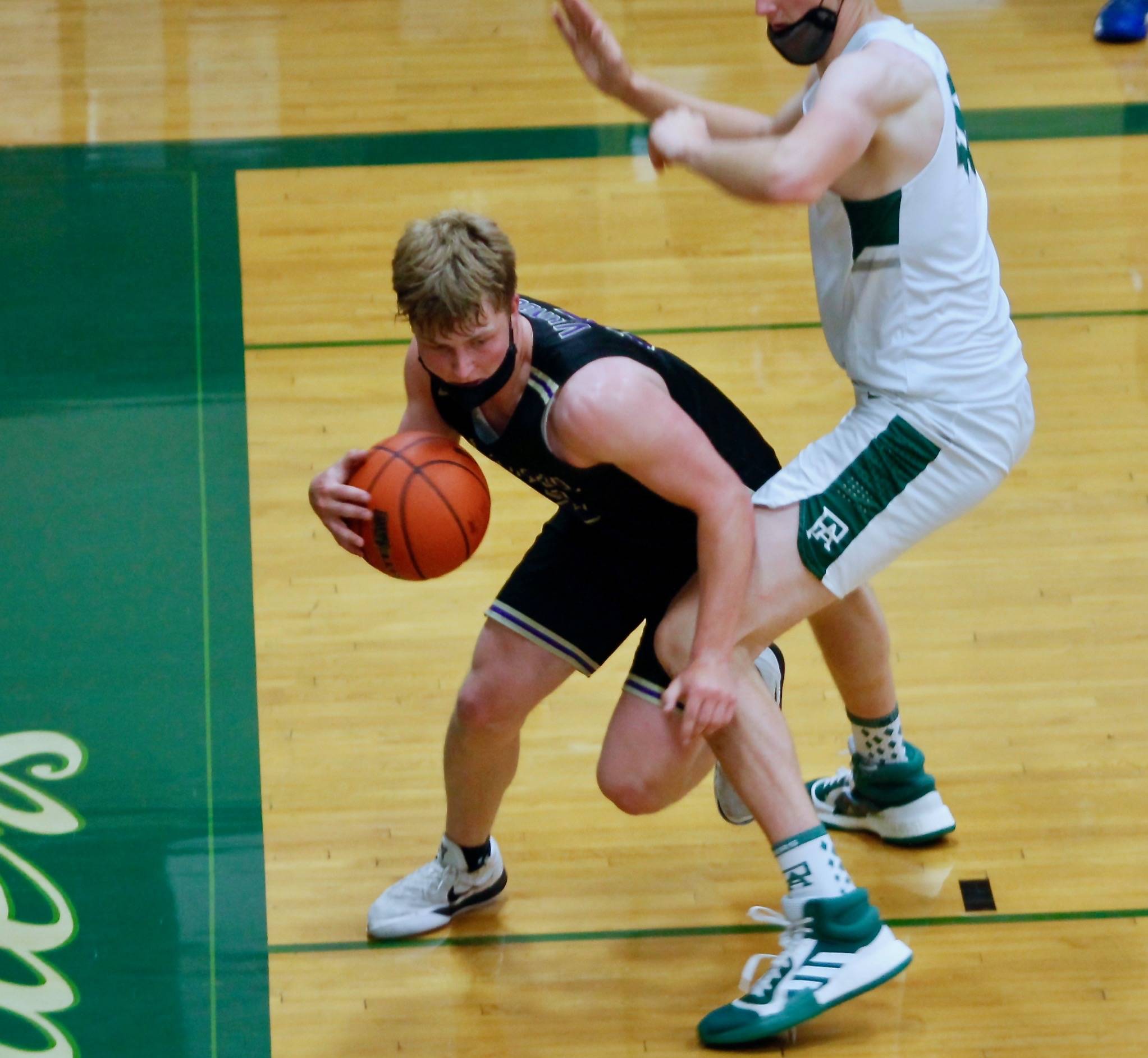 Colton Bower tries to find room with 6-foot-9 John Vaara guarding him close in the league championship game. (Mark Krulish/Kitsap News Group)