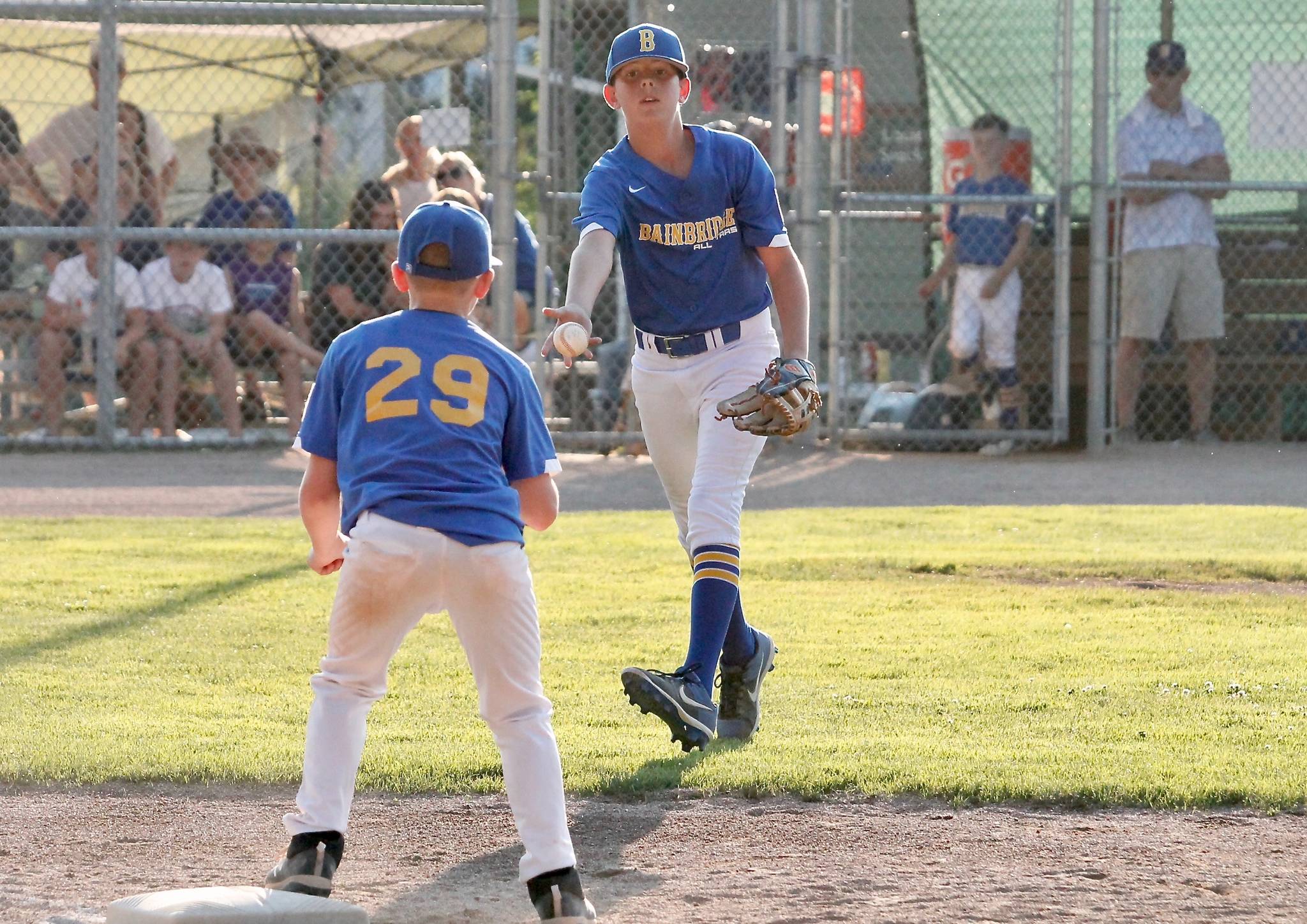 Ryan Rohrbacher flips the ball to Ely Olesen at first base after snagging an easy grounder. (Mark Krulish/Kitsap News Group)