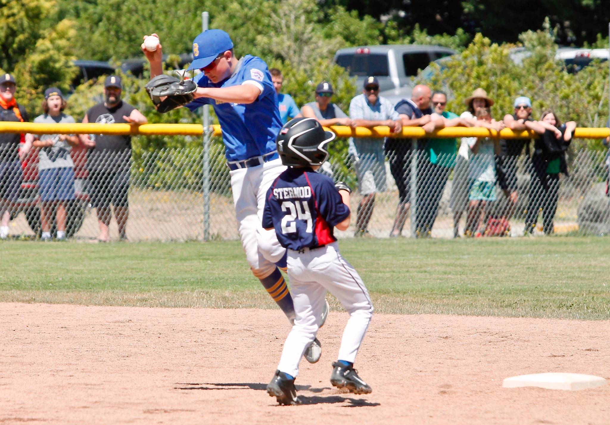 Dominic D’Amico makes the final out of the game at second base and avoids a collision with a Gig Harbor base runner in the District 2 championship. (Mark Krulish/Kitsap News Group)