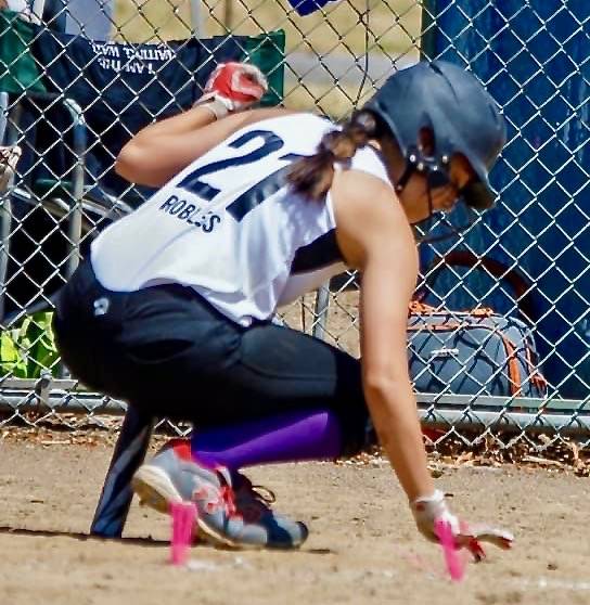 Cadence Robles reaches down into the dirt to honor the memory of classmate Gee Still, who recently passed away in an accident. Kris Bartlett Courtesy Photos