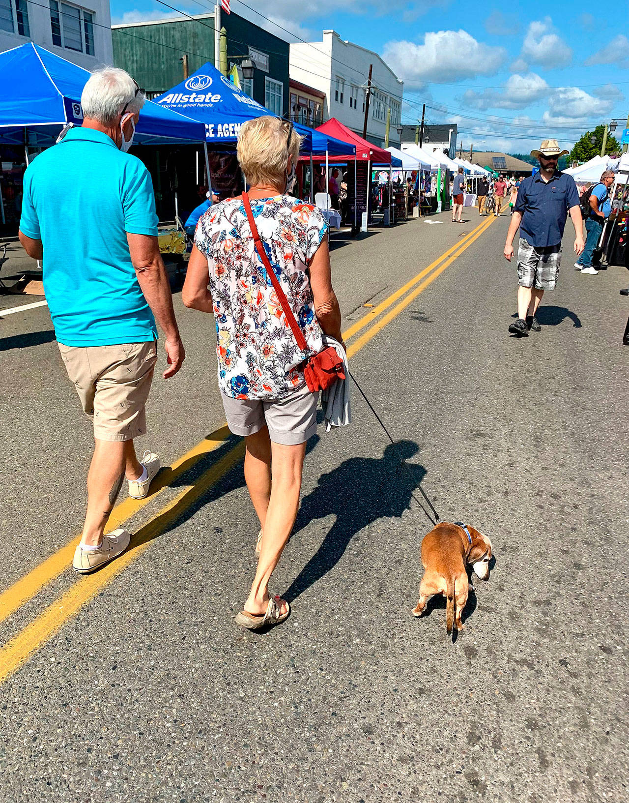 A couple and their curious dachshund meander along Bay Street in downtown Port Orchard during the CRUZ Car Show and Fathoms Festival By The Bay activities on Sunday. (Bob Smith | Kitsap Daily News)