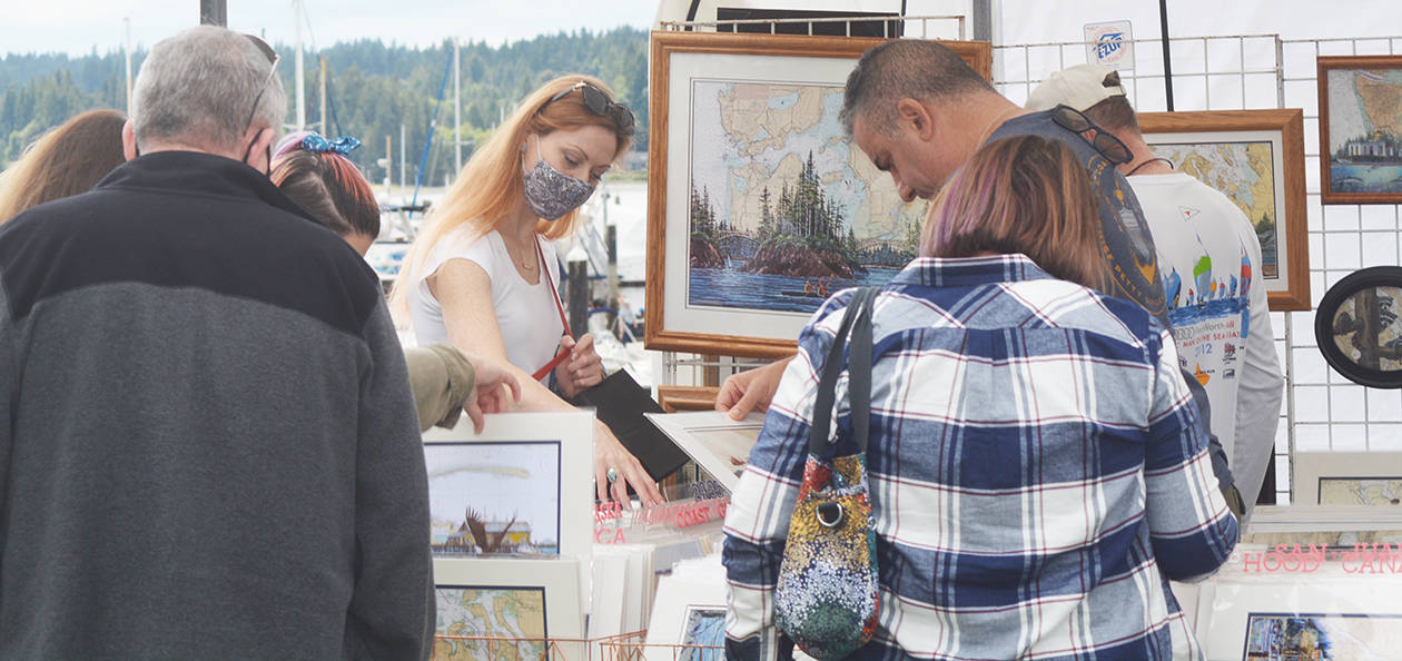 Visitors look at artwork at one of the booths. Steve Powell/North Kitsap Herald