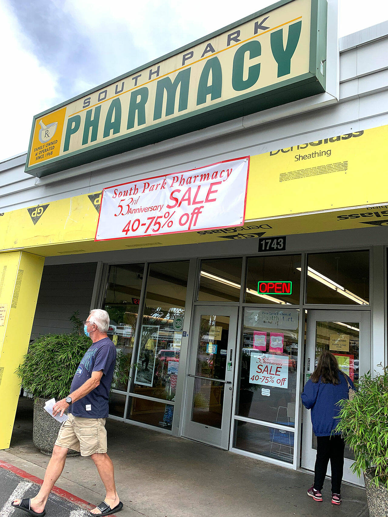 South Park Pharmacy customers hurriedly enter and exit the store before it closed last week. (Bob Smith | Kitsap Daily News)