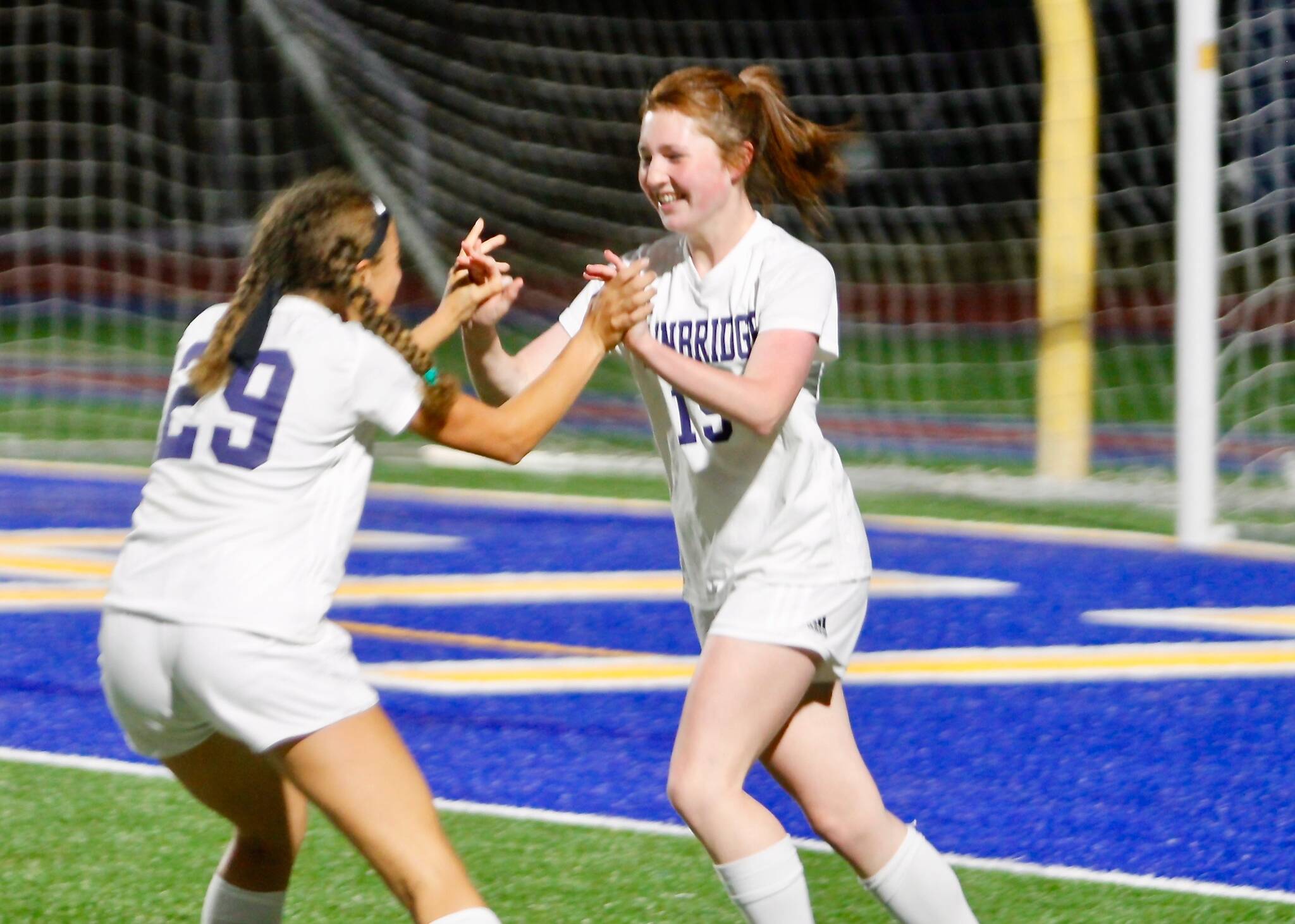 Sky Henderson (29) rushes to congratulate teammate Avery Pujolar after scoring her third goal of the game in a 5-0 win over Bremerton. (Mark Krulish/Bainbridge Island Review photos)