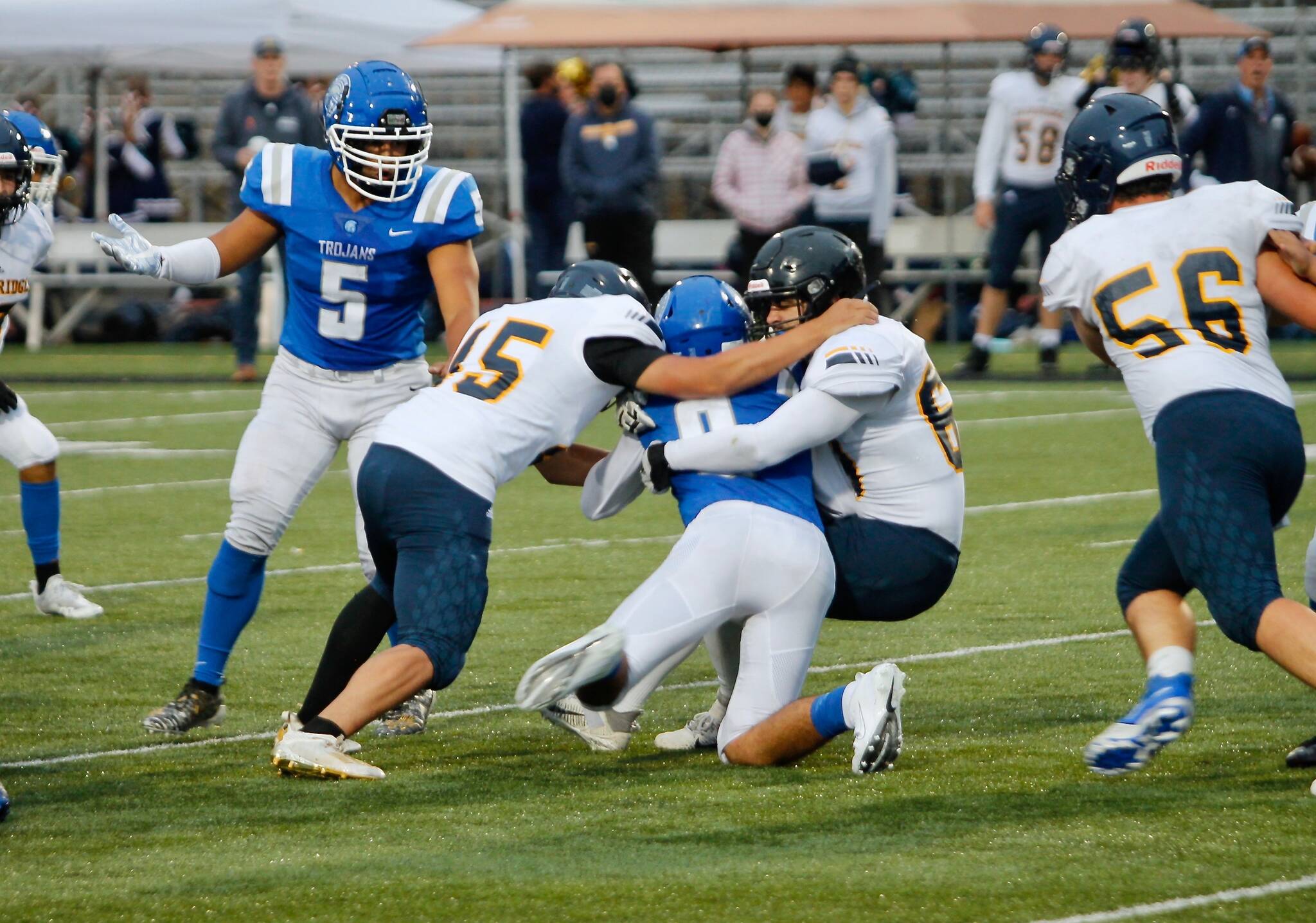 Bainbridge’s Jacob Dorsey (45) helps bring down Olympic’s Luke Silva (9) during Friday night’s matchup. The Trojans prevailed 28-24. (Mark Krulish/Kitsap News Group)