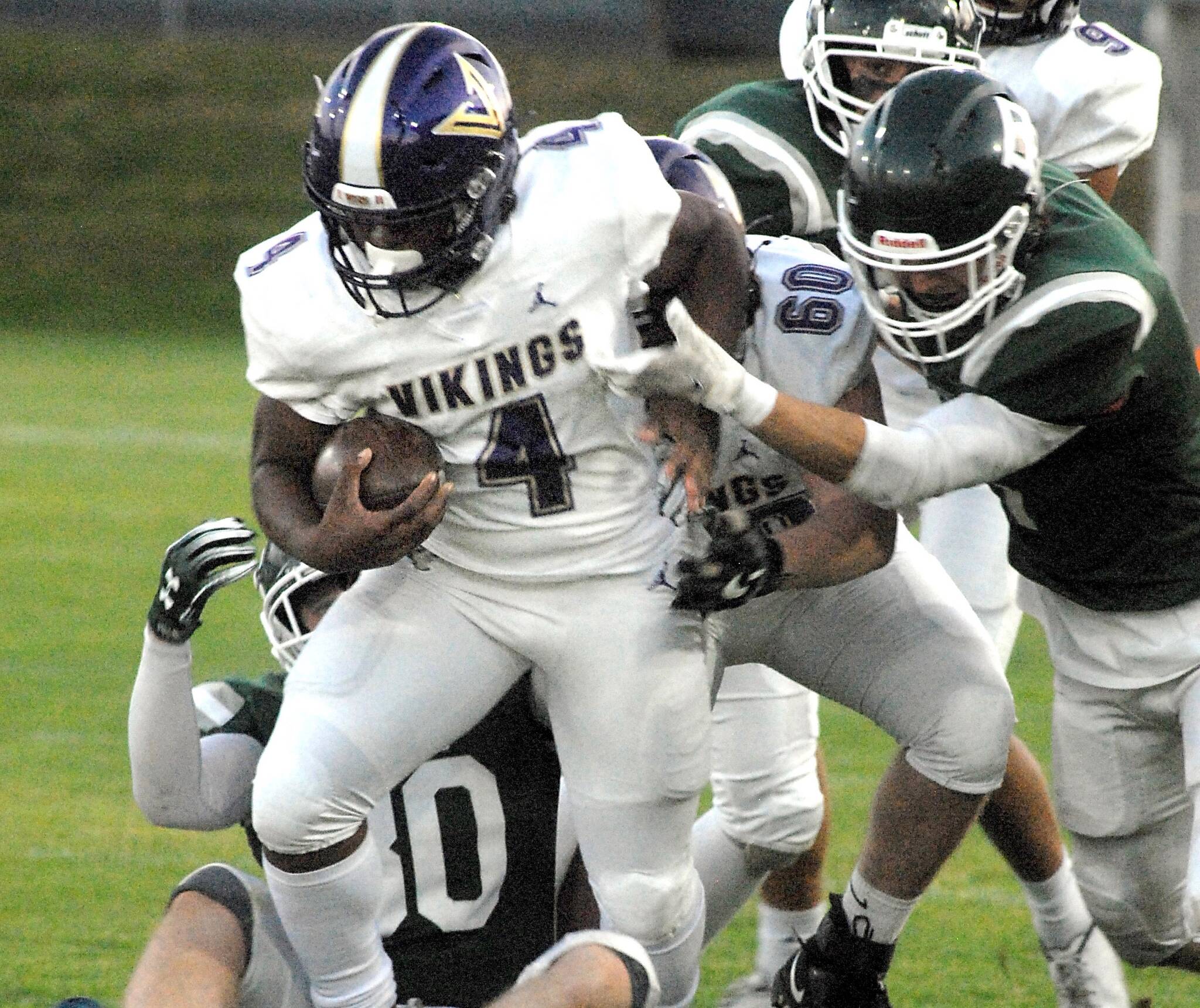 North Kitsap’s Zeke Harris, front, gets an assist from teammate Lincoln Hawkins before being wrapped up by the Port Angeles defense on Friday night at Port Angeles Civic Field. (Keith Thorpe/Peninsula Daily News)
