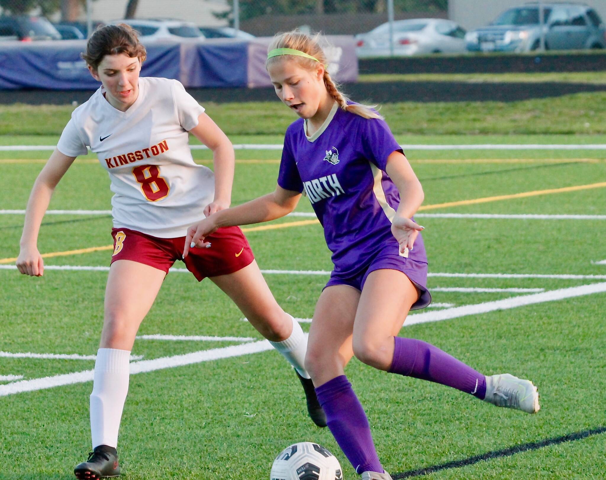 Evelyn Beers looks to make a pass back to the middle of the field as she’s defended by Kingston’s Genevieve Upton. (Mark Krulish/Kitsap News Group)