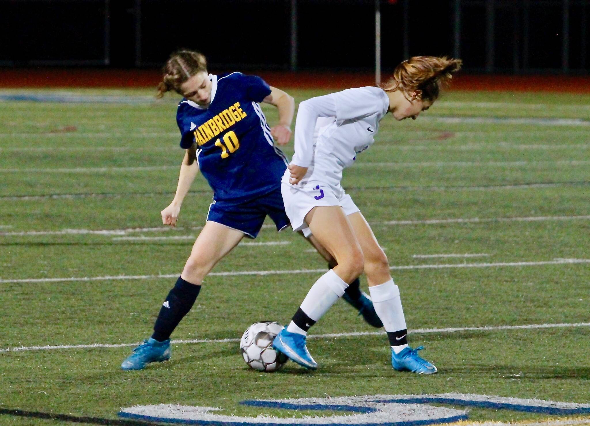 Bainbridge senior Maddy Brown looks to pry the ball loose from a Sequim player during her team’s 1-0 win Thursday night. Mark Krulish/Bainbridge Island Review photos