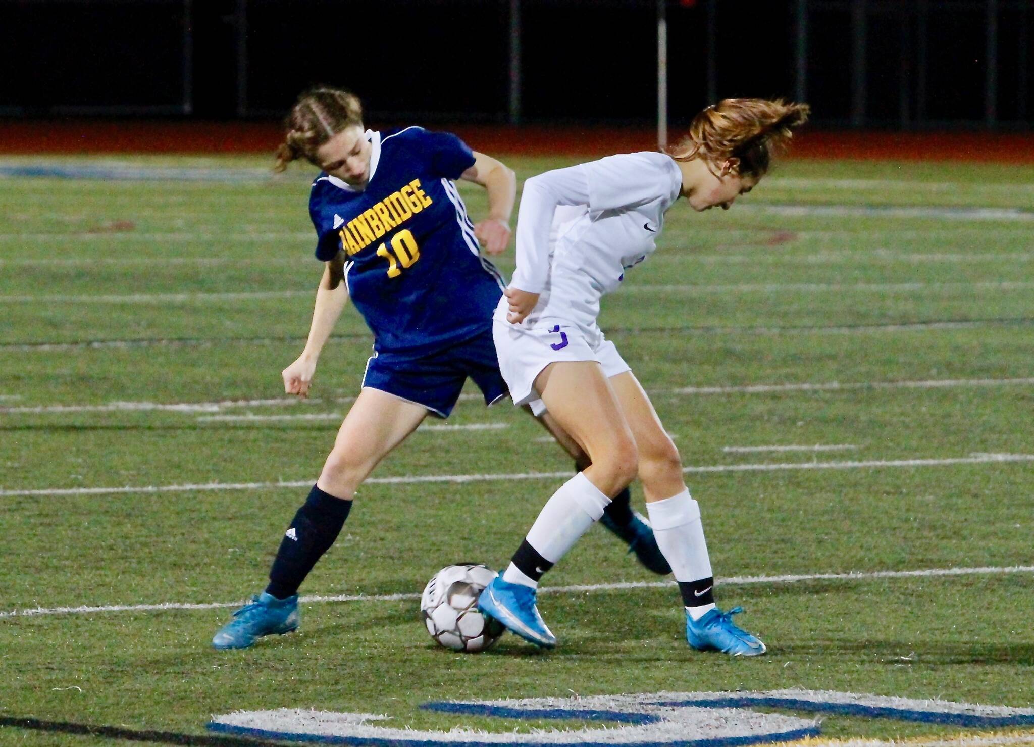 Bainbridge senior Maddy Brown looks to pry the ball loose from a Sequim player during her team’s 1-0 win Thursday night. Mark Krulish/Bainbridge Island Review photos