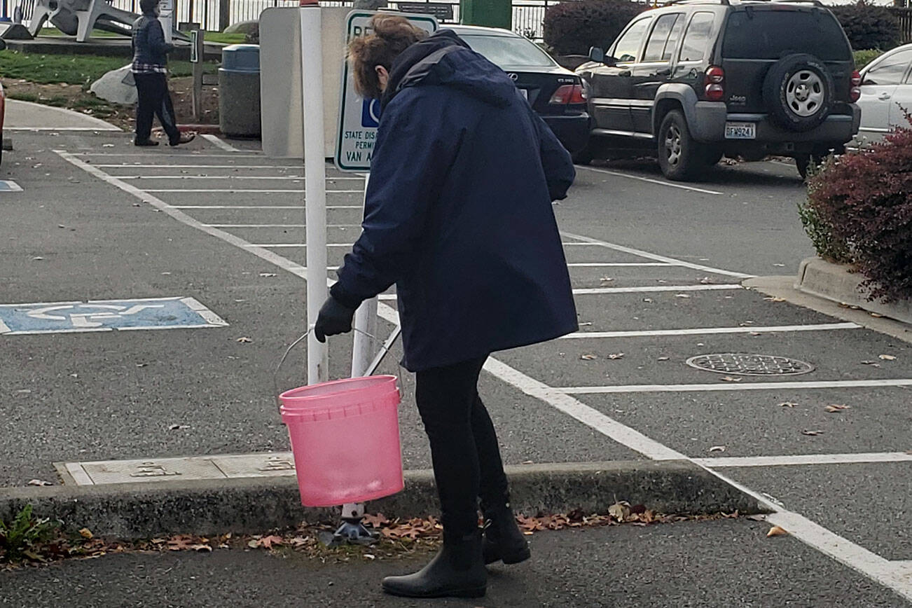 Another volunteer picks up trash in the nearby parking lot.
