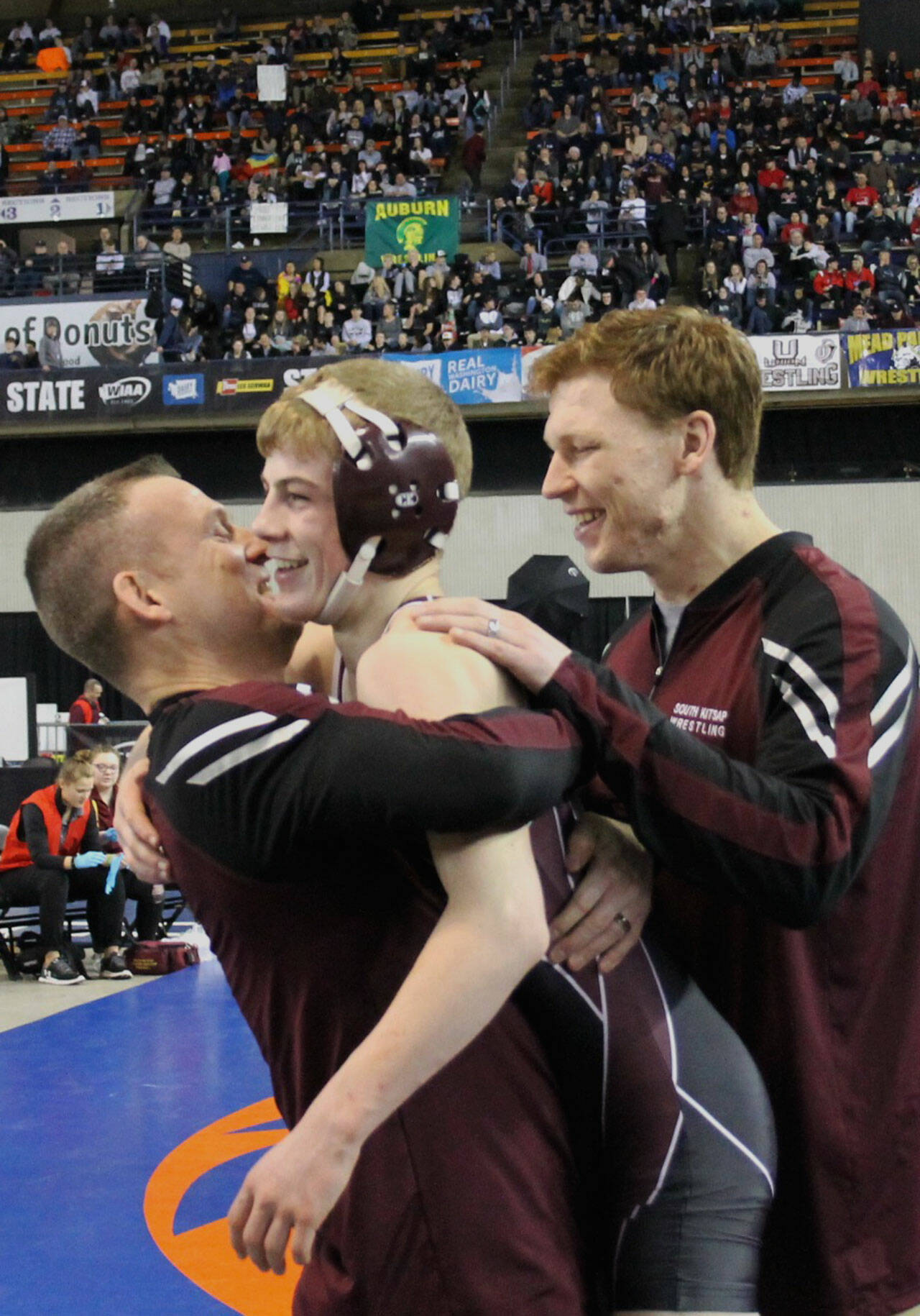 South Kitsap wrestler Xavier Eaglin gets a hug from head coach Chad Nass as he won his first-ever state championship, which contributed to the Wolves winning the overall 4A team title. (File photo)