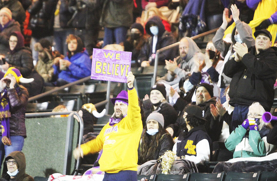 A super fan in the stands waves a sign of support at the start of the game.