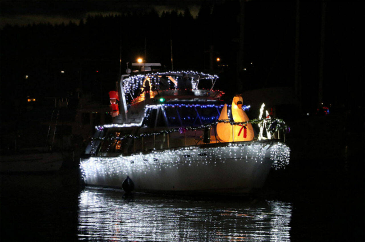 The Christmas lights reflect nicely in the water on this boat.