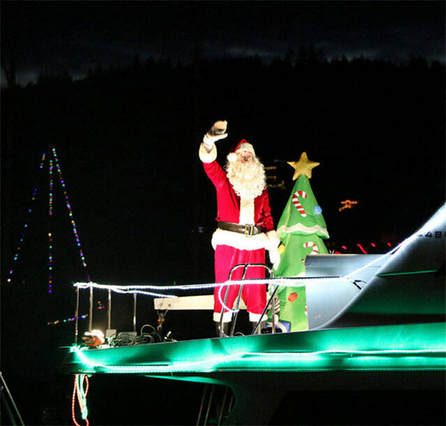 Santa waves from his boat during the 50th Lighted Ships Parade in 2019. Herald file photos