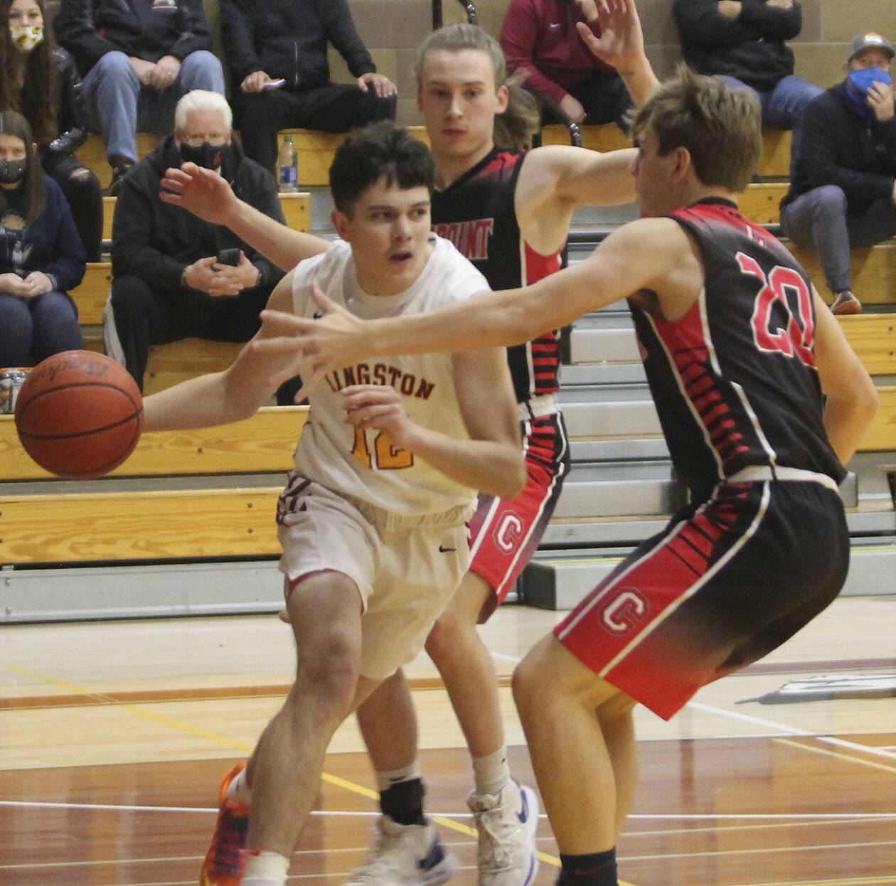 Kingston’s Dakota Standley (12) drives the baseline against a Crosspoint double team. Steve Powell/North Kitsap Herald photographs