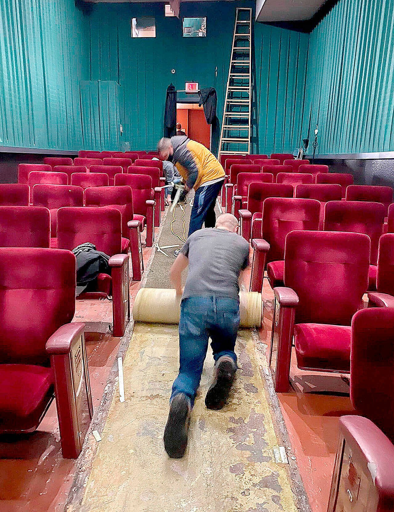 Volunteers roll up the aisle carpet runner in the newly renamed Historic Polaris Theatre that was soiled by recent water leakage. The Bay Street building once housed Port Orchard movie houses of various names — most recently the Dragonfly Cinema. (Facebook photo)