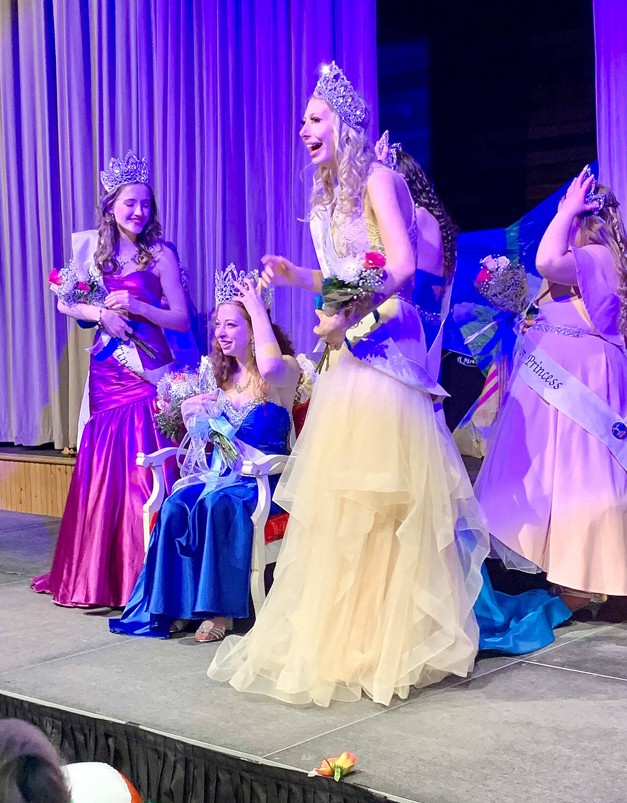A stunned Rebecca Greenberg (sitting on throne) is crowned Fathoms O’ Fun Festival’s Queen and her fellow contestants quickly gather around to congratulate her. (Bob Smith | Kitsap Daily News)