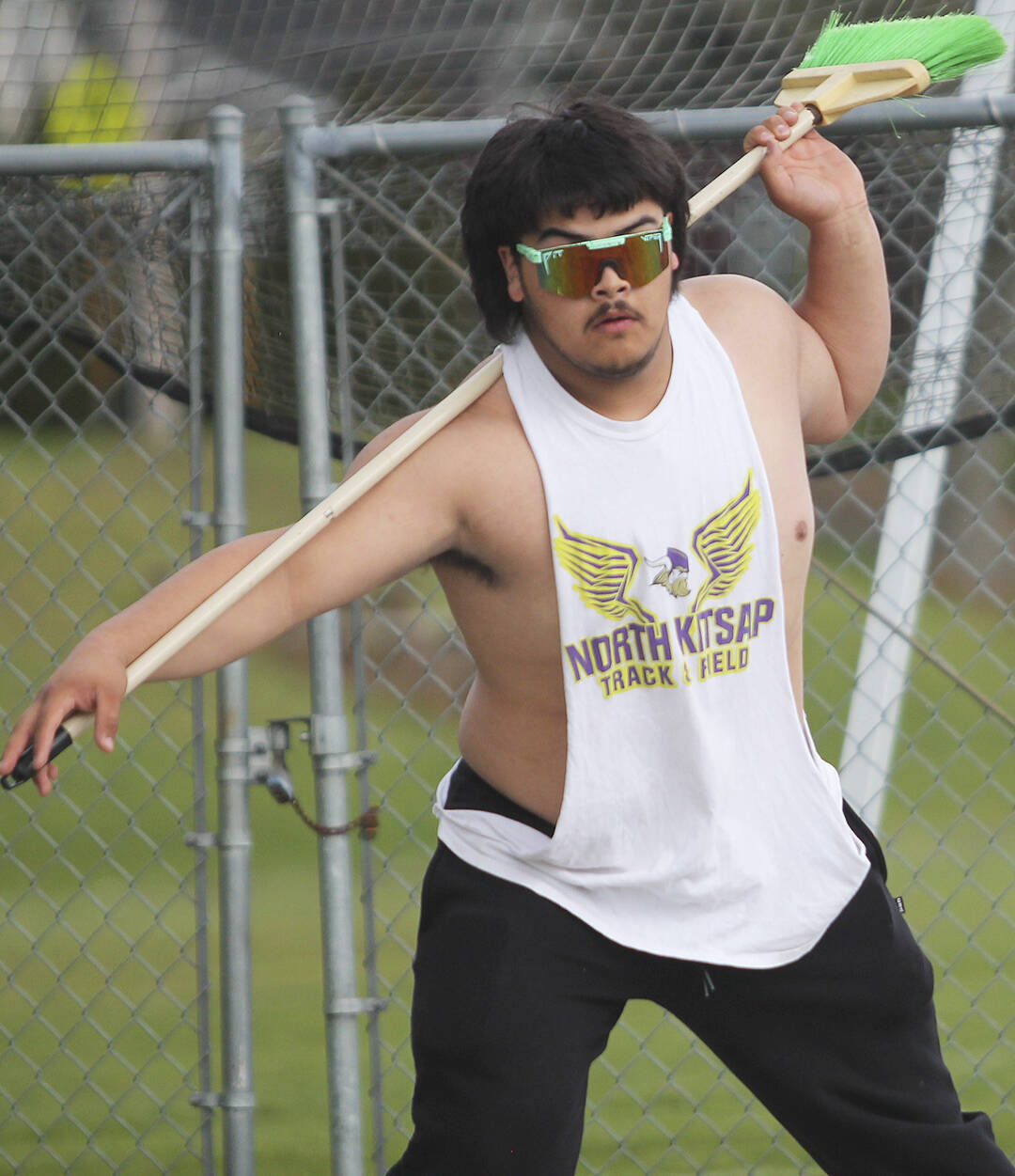 Viking sophomore Jesus Mares uses a broom to practice his form for the turns in the discus.