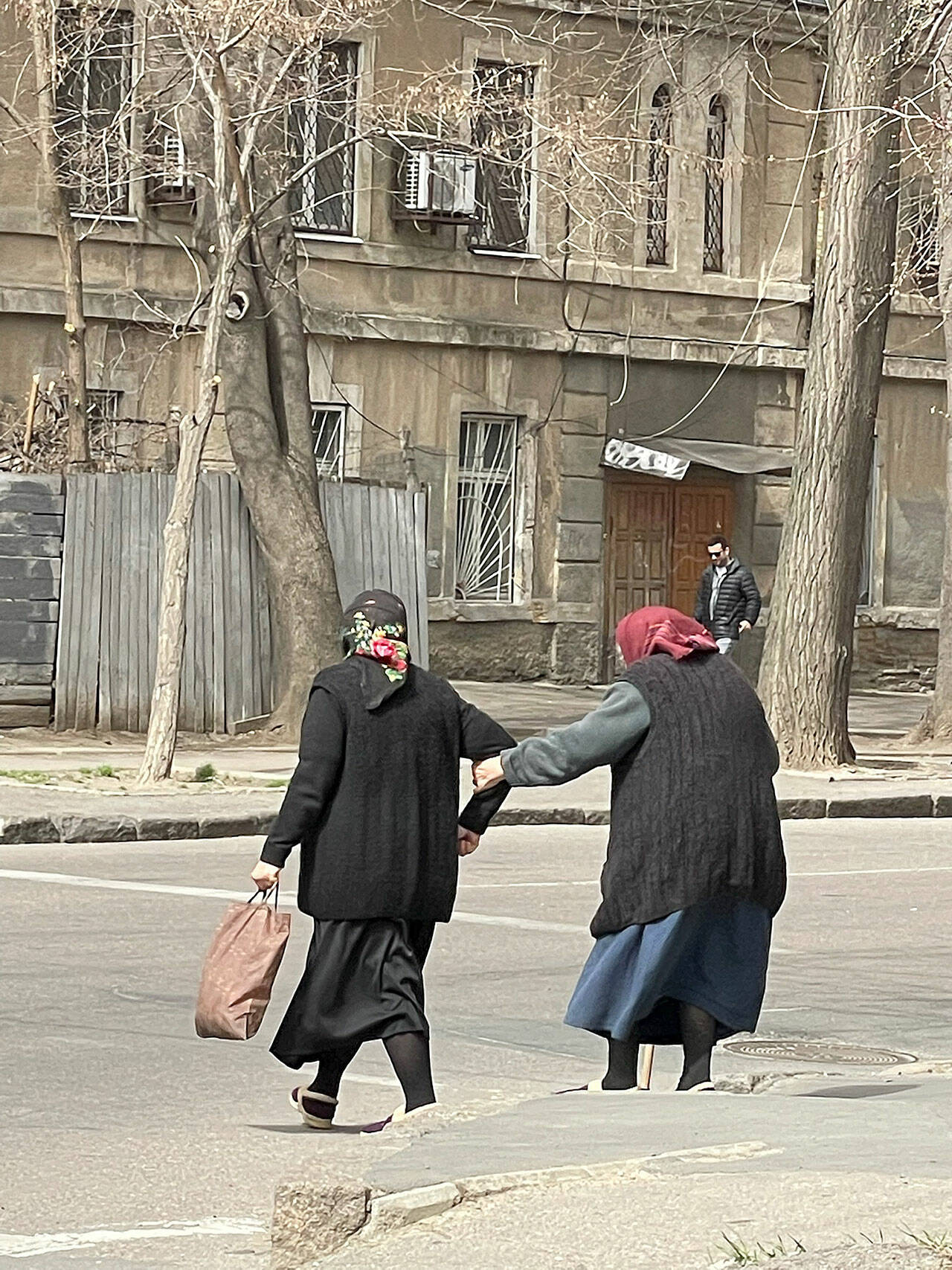 Two elderly babushkas lock arms to cross the street. (Courtesy photo)