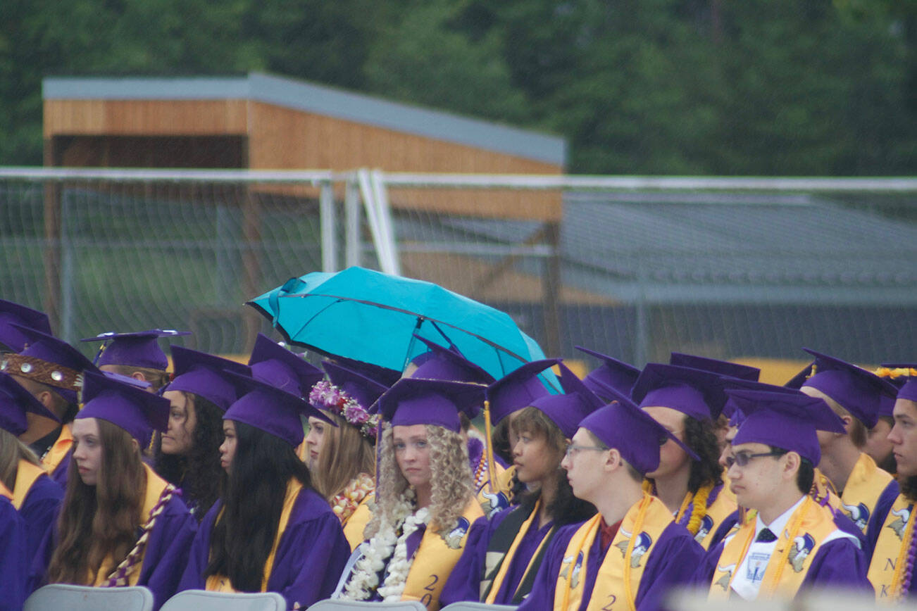 Graduates look on as they wait to receive their diplomas.