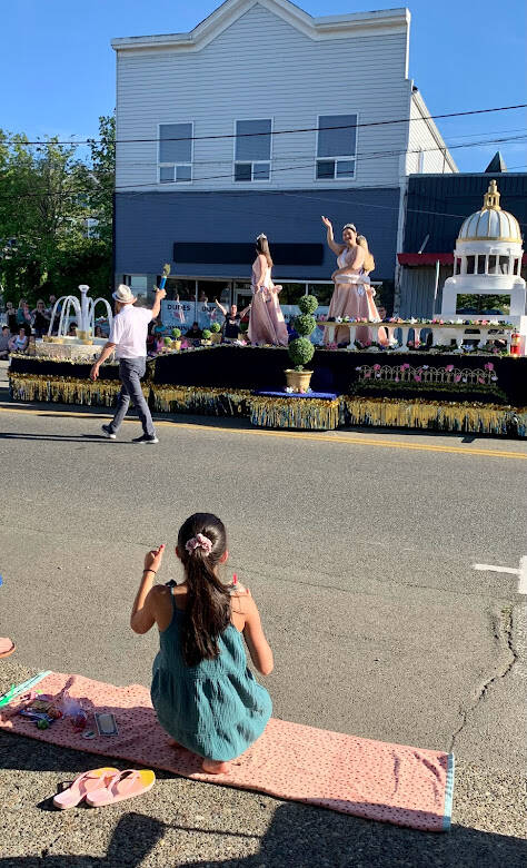 A little parade watcher exchanges a wave with a princess on a float. (Bob Smith | Kitsap News Group)