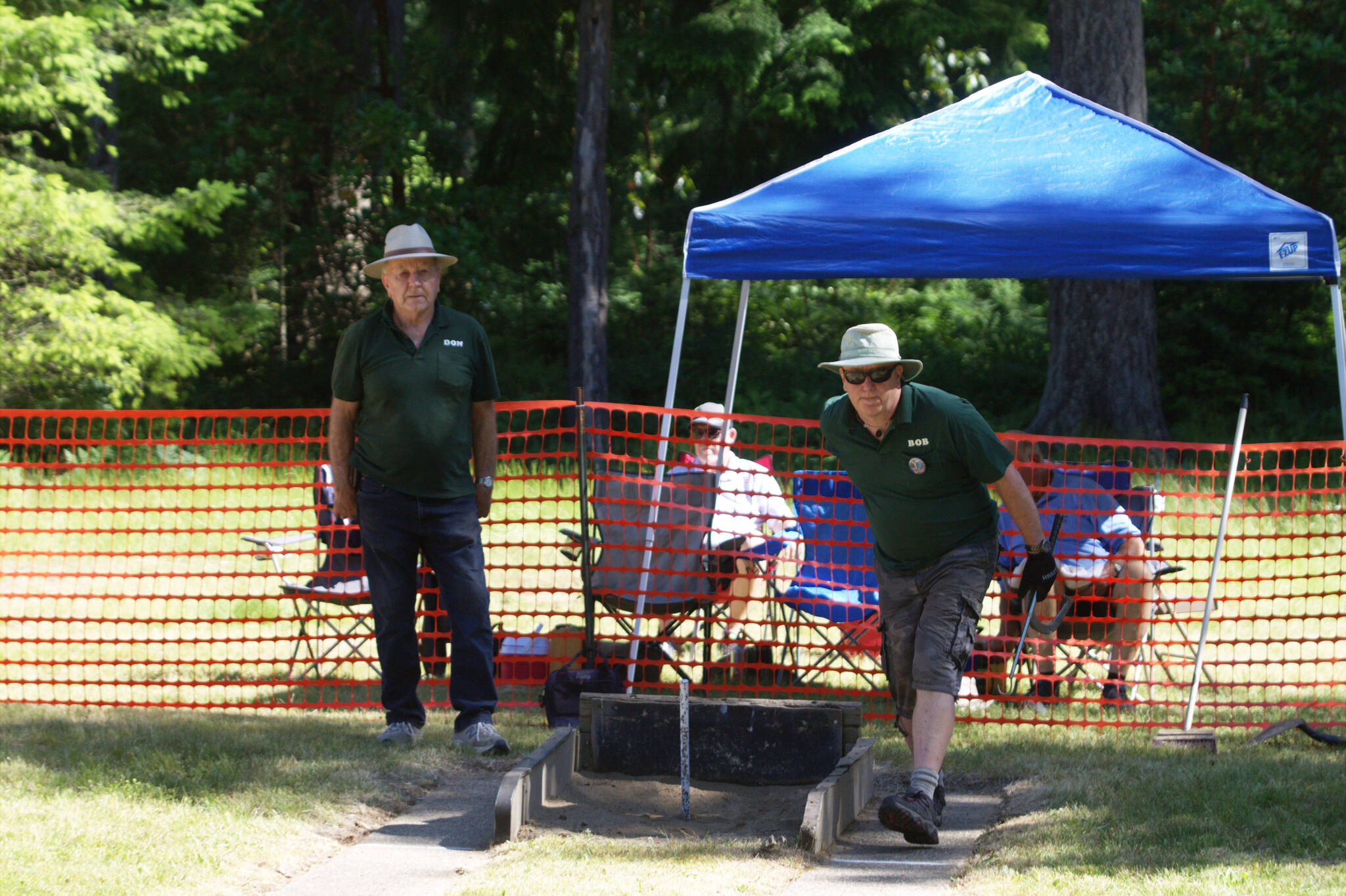 Two gentlemen compete in a game of horseshoes at South Kitsap Regional Park.