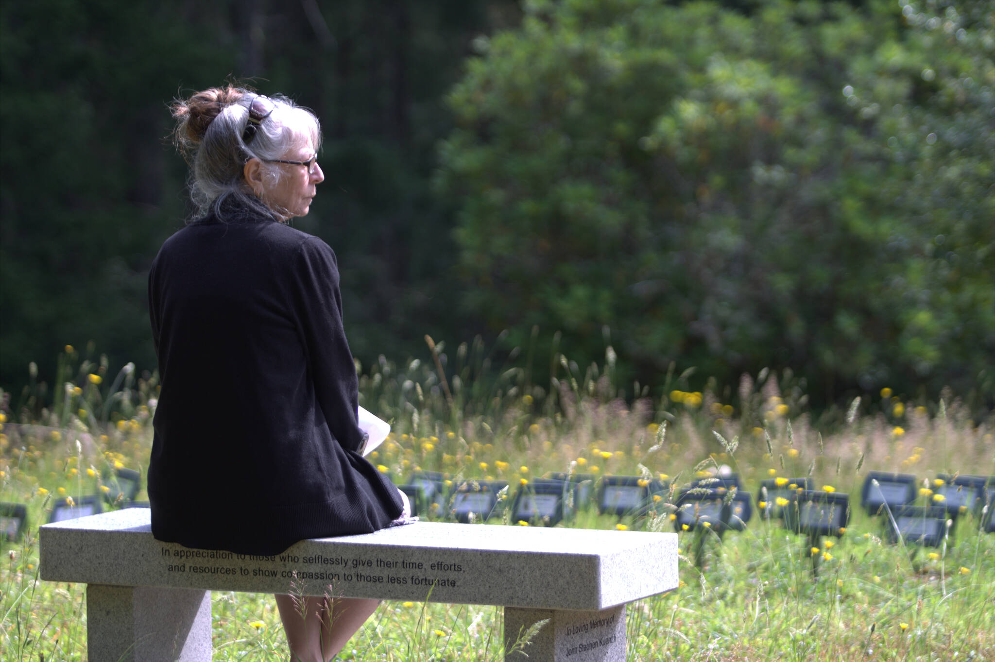 A woman sits at the indigent grave plot at Silverdale Pioneer Cemetery. Elisha Meyer/Port Orchard Independent Photos