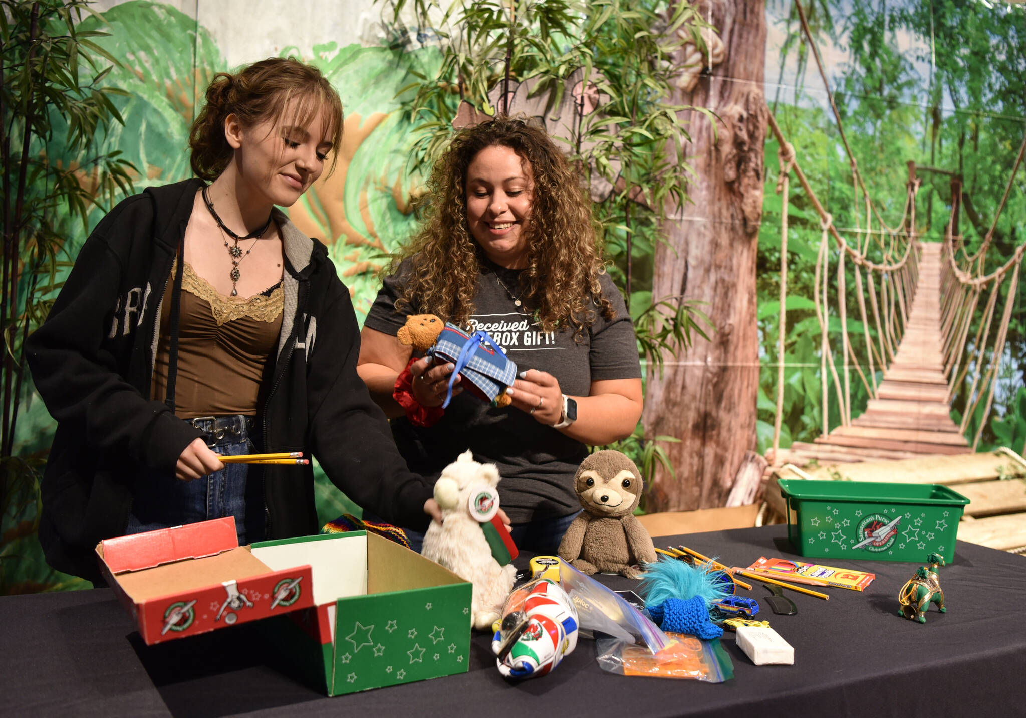 Lillian Kirtley and Veronica Miranda pack a shoebox for Operation Christmas Child at Calvary Chapel Church in Poulsbo. Nancy Treder/Kitsap News Group Photos