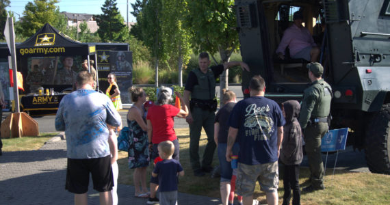 Families gather around a heavy-duty vehicle used by one of Kitsap County’s special units.