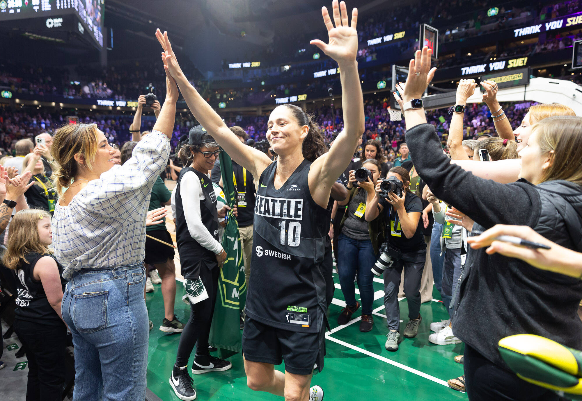 Sue Bird high fives fans as she leaves the court after the game. Neil Enns/Seattle Storm Courtesy Photo