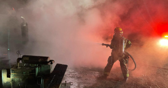 NKF&R firefighter/paramedic Janelle Randles fights a shed and dump truck fire near Hansville Tuesday night. Courtesy Photos