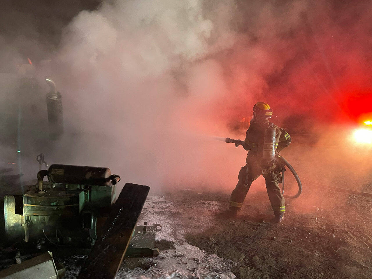 NKF&R firefighter/paramedic Janelle Randles fights a shed and dump truck fire near Hansville Tuesday night. Courtesy Photos