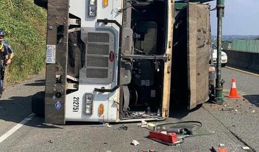 The garbage truck lies on its side after tipping over due to a flat tire. Courtesy Photo