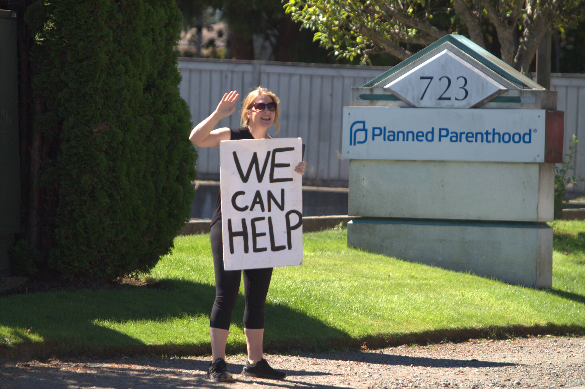 A protester waves to cars passing by the Planned Parenthood in Bremerton. Elisha Meyer/Kitsap News Group