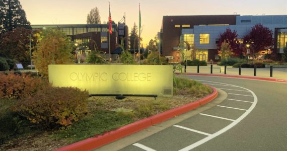 Daylight's end turns on the lights of the Olympic College sign at one of the campus entrances. Elisha Meyer/Kitsap News Group