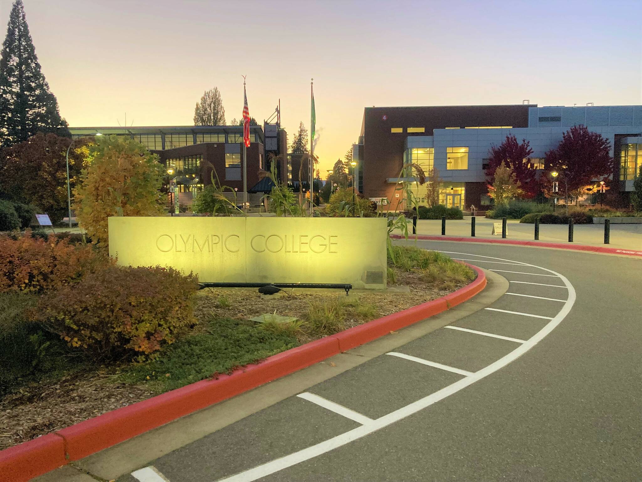 Daylight's end turns on the lights of the Olympic College sign at one of the campus entrances. Elisha Meyer/Kitsap News Group