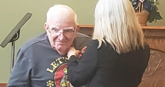 A veteran who lives at Brookdale Montclair in Poulsbo receives a pin for his years of military service. Tyler Shuey/Kitsap News Group Photos