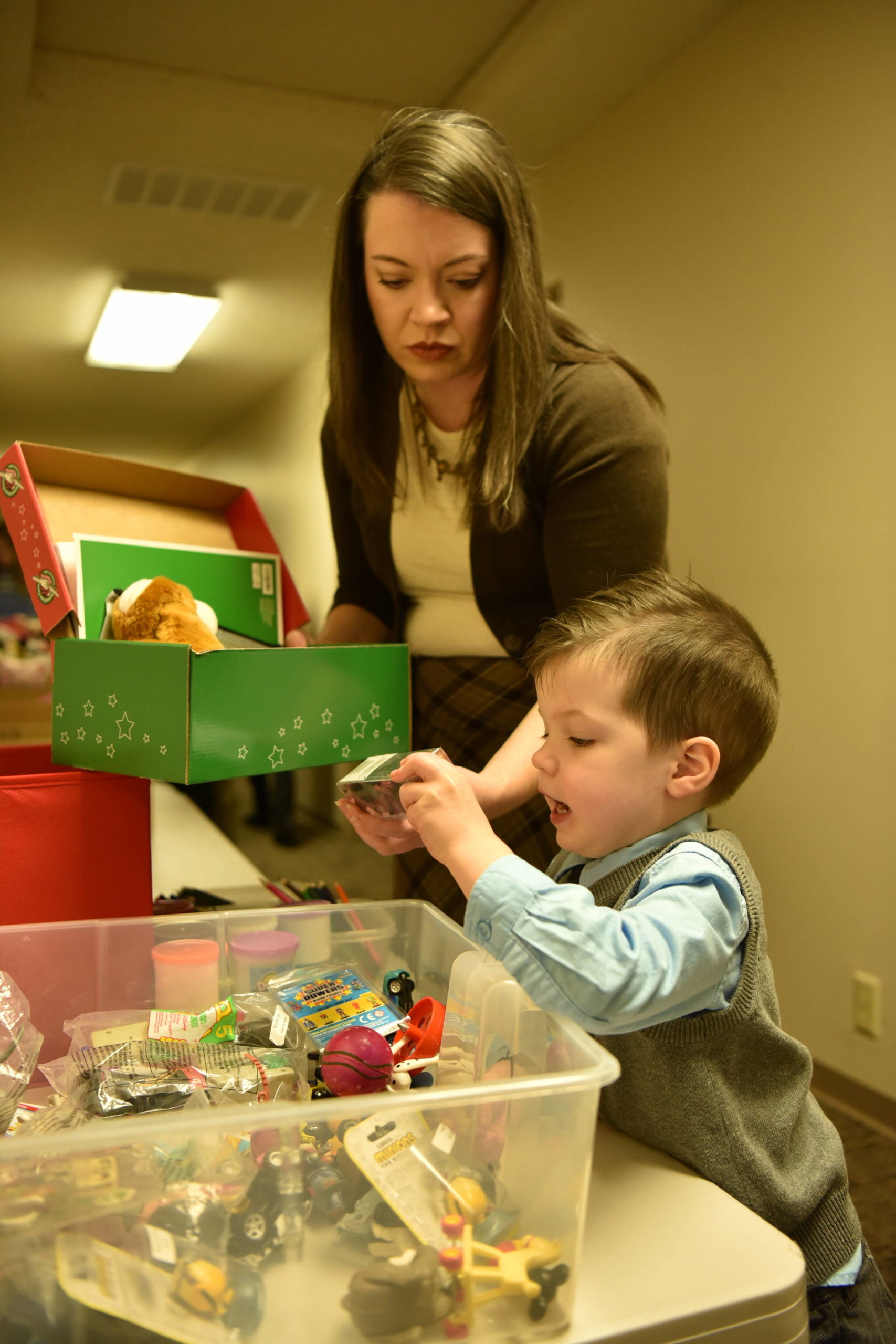 Rachel Garaard helps her son, Luke, 3, fill a box with items for Operation Christmas Child. Nancy Treder/Kitsap News Group Photos