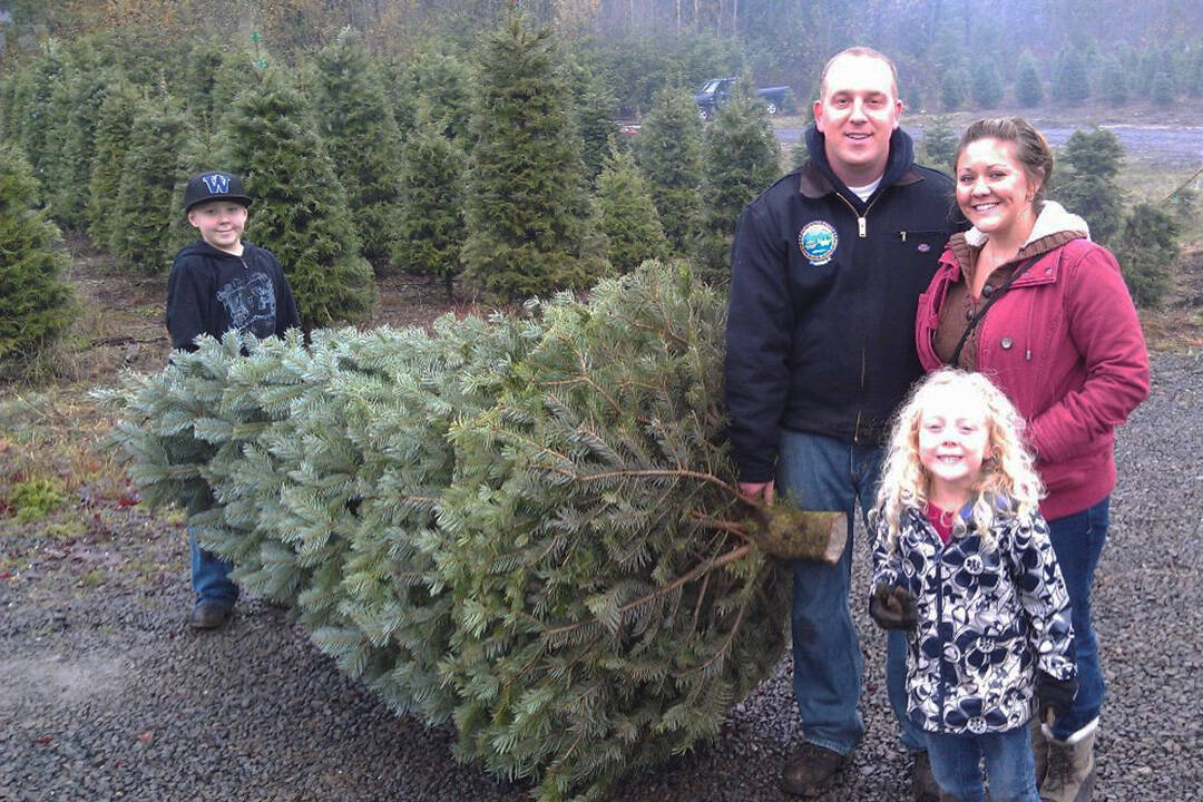 Adam and Sarah Stuart, with their kids Ethan and Caitlin, show off their prize Christmas tree. Olmsted Tree Farms Courtesy Photo