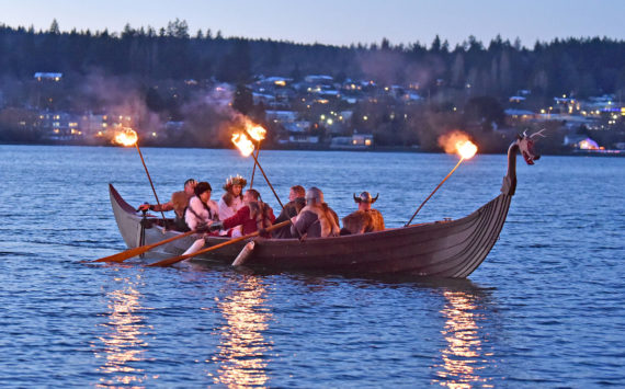 At dusk, the Poulsbo Sons of Norway Vikings escort the Lucia Bride by boat to shore at Waterfront Park in Poulsbo, where she lights the annual bonfire after the Viking King makes the Winter Solstice Proclamation. Nancy Treder/Kitsap News Group Photos