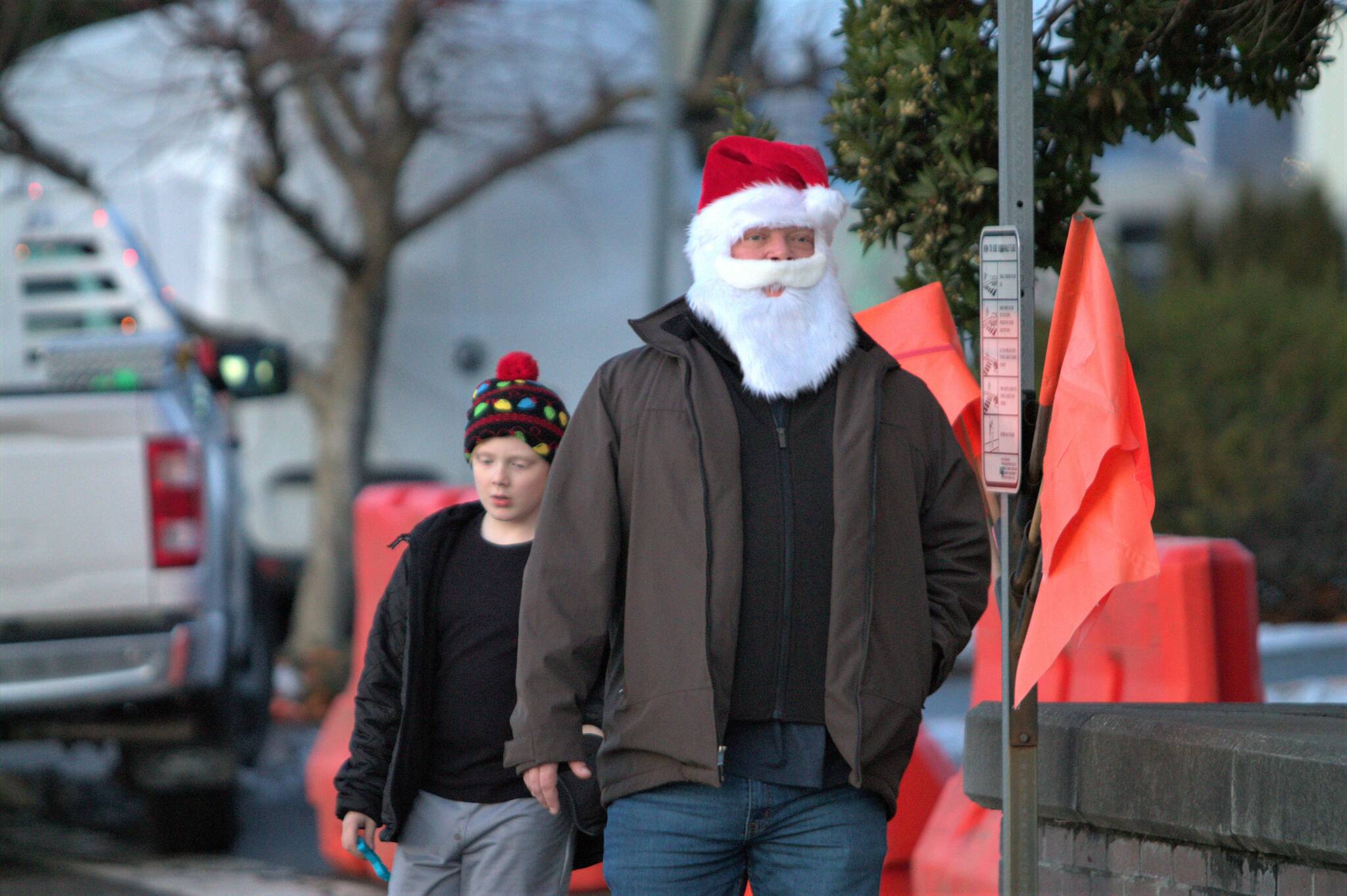A casually-dressed Santa Claus walks to City Hall.