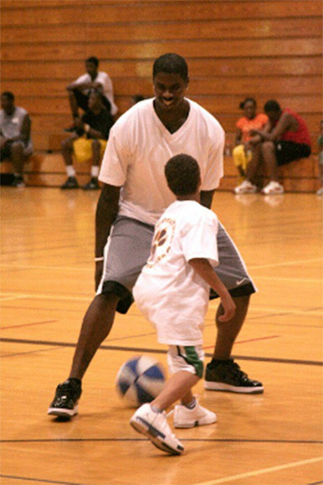 Former NBA player Marvin Williams plays with a youngster during one of his basketball camps in his hometown of Bremerton. File Photos