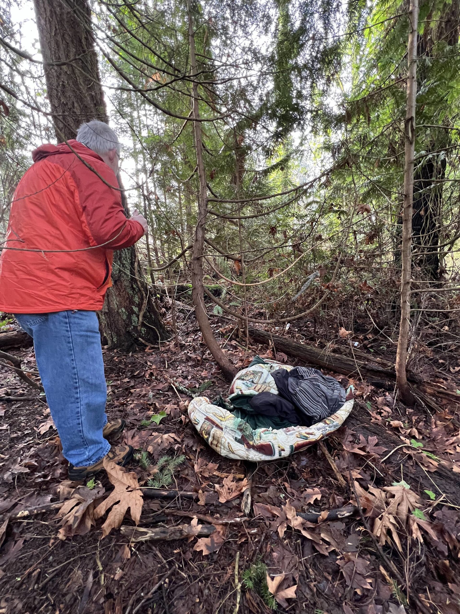 John Dembowski takes a closer look at a sleeping spot in a park in Poulsbo.